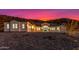 Exterior view of a single-story home with desert landscaping and a vibrant sunset sky at 9357 W Canyon Verde Dr, Casa Grande, AZ 85194