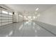 Spacious three-car garage with epoxy flooring, white walls, and natural lighting from windows at 9357 W Canyon Verde Dr, Casa Grande, AZ 85194