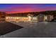Three car garage with a wide concrete driveway at dusk at 9357 W Canyon Verde Dr, Casa Grande, AZ 85194