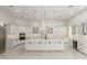 Modern kitchen with white cabinetry, marble floors, large island with pendant lighting, and stainless steel appliances at 9357 W Canyon Verde Dr, Casa Grande, AZ 85194