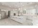 Spacious kitchen featuring a large island, white cabinets, stainless steel appliances, and marble floors at 9357 W Canyon Verde Dr, Casa Grande, AZ 85194
