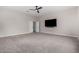 Spacious bedroom featuring neutral walls, plush carpet, a ceiling fan, and entertainment system connections at 9825 E Gary St, Mesa, AZ 85207