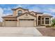 Inviting two-story home featuring a three-car garage, desert landscaping, and a tile roof at 9825 E Gary St, Mesa, AZ 85207