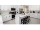 Modern kitchen featuring white cabinets, stainless steel appliances, quartz countertops, and an island with seating at 9825 E Gary St, Mesa, AZ 85207