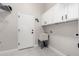 Laundry room with a utility sink, wall cabinets, and wire shelving at 9825 E Gary St, Mesa, AZ 85207