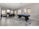 Open-concept living room features a fireplace, neutral tones, and a billiards table for entertainment at 9825 E Gary St, Mesa, AZ 85207