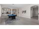 Bright, open living room with a billiards table and access to the kitchen through arched doorways at 9825 E Gary St, Mesa, AZ 85207