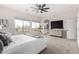 Main bedroom featuring large windows, a ceiling fan, neutral decor, soft carpet, and an attached bathroom at 9825 E Gary St, Mesa, AZ 85207