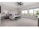 Light-filled main bedroom with large windows, neutral colors, soft carpet, and a comfortable seating area at 9825 E Gary St, Mesa, AZ 85207
