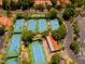 Aerial view of tennis courts and community amenities nestled amongst mature trees and residential area at 1010 N Osprey Ct, Gilbert, AZ 85234