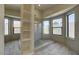 Bright bathroom featuring a spacious glass shower, stone floor, modern fixtures, and multiple windows for natural light at 1010 N Osprey Ct, Gilbert, AZ 85234