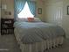 Cozy bedroom with blue curtains, a comfortable bed, and a built-in bookshelf at 1010 N Osprey Ct, Gilbert, AZ 85234