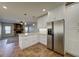 Well-lit kitchen with stainless steel refrigerator and view into the spacious living area with fireplace at 1010 N Osprey Ct, Gilbert, AZ 85234