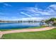 Beautiful lake view with a boat dock, green lawn, and homes lining the shore at 1010 N Osprey Ct, Gilbert, AZ 85234
