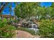 Picturesque water feature with a rocky cascade surrounded by vibrant flowers and lush landscaping, offering a peaceful retreat at 1010 N Osprey Ct, Gilbert, AZ 85234