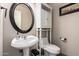 A half bath featuring a stylish mirror, a sink, and toilet at 1014 W Mulberry Dr, Chandler, AZ 85286