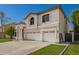 Charming two-story home with a three car garage, well-manicured lawn, and an arched entryway at 1014 W Mulberry Dr, Chandler, AZ 85286