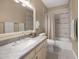 A full bathroom is decorated with a marble countertop, white cabinets, and a shower-tub combination at 10623 E Acacia Dr, Scottsdale, AZ 85255