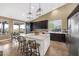 Well-lit kitchen featuring a large island, modern lighting, stainless steel appliances, and dark cabinetry at 10623 E Acacia Dr, Scottsdale, AZ 85255