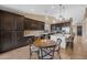 Modern kitchen featuring dark cabinets, a large island, stainless steel appliances, and a breakfast nook at 10623 E Acacia Dr, Scottsdale, AZ 85255