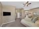 Generous main bedroom includes carpet floors, a tv, neutral walls, and views into the main bathroom at 10623 E Acacia Dr, Scottsdale, AZ 85255