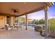 Inviting covered patio with outdoor dining and seating area overlooking the pool at 10623 E Acacia Dr, Scottsdale, AZ 85255