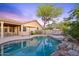 Backyard pool features a stone border and is surrounded by an outdoor patio with ample seating and a grill at 10623 E Acacia Dr, Scottsdale, AZ 85255