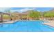 A community pool with lounge chairs and shaded seating, set against a backdrop of mountains at 10623 E Acacia Dr, Scottsdale, AZ 85255