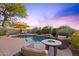 Backyard pool with a beautiful lounge area, complete with an umbrella and a fire pit, against a picturesque sky at 10623 E Acacia Dr, Scottsdale, AZ 85255