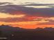 Mountain range view during a vivid sunset, with dramatic colors over the rooftop in the foreground at 10623 E Acacia Dr, Scottsdale, AZ 85255