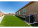 Backyard with artificial grass, wall and AC unit on the side of the house at 10949 N 183Rd Dr, Surprise, AZ 85388