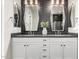 This bathroom features dual sinks, gray countertops, white cabinets, and decorative tile at 10949 N 183Rd Dr, Surprise, AZ 85388