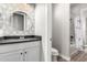 Beautiful bathroom with mosaic tile wall, round mirror and dark countertop sink at 10949 N 183Rd Dr, Surprise, AZ 85388