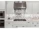Close-up of the modern kitchen features a stainless steel range hood and white cabinetry at 10949 N 183Rd Dr, Surprise, AZ 85388