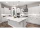 Bright kitchen with a large island features white cabinets, stainless appliances, and stylish backsplash at 10949 N 183Rd Dr, Surprise, AZ 85388