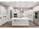 A bright kitchen boasts white cabinets, stainless appliances, a large island, and stylish backsplash at 10949 N 183Rd Dr, Surprise, AZ 85388