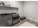 Clean laundry room featuring modern washer and dryer, ample storage and wood-look tile floors at 10949 N 183Rd Dr, Surprise, AZ 85388