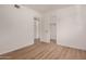 Clean, simple bedroom features wood-look flooring, white walls, and access to closet space at 1115 E Carter Dr, Tempe, AZ 85282