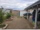 The backyard features a gravel area, block fence, mature trees, and storage shed at 11770 W Aster Dr, El Mirage, AZ 85335