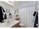 Bright bathroom with decorative anchors, white vanity, a wooden-framed mirror and shower at 1241 E Elm Rd, San Tan Valley, AZ 85140