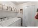 Functional laundry room with white washer, dryer, storage shelves, and access to exterior at 1241 E Elm Rd, San Tan Valley, AZ 85140
