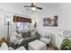 Cozy living room with gray sofa, decorative pillows, accent chair, and window with a ceiling fan at 1241 E Elm Rd, San Tan Valley, AZ 85140