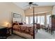Serene main bedroom featuring vaulted ceilings, a four-poster bed, and a view of the bay window at 1241 E Elm Rd, San Tan Valley, AZ 85140