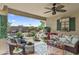 An outdoor patio space with seating, a ceiling fan and a view to a landscaped garden at 1241 E Elm Rd, San Tan Valley, AZ 85140
