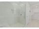 Modern shower with glass enclosure and neutral tile work with open access to large walk-in closet at 1272 W Camina Buena Vis, Queen Creek, AZ 85140