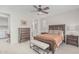 Well-appointed bedroom with a ceiling fan, dresser, and a view into an adjacent bathroom and laundry area at 1272 W Camina Buena Vis, Queen Creek, AZ 85140