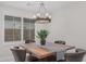 Stylish dining room featuring a modern chandelier and a wooden table with leather chairs at 1272 W Camina Buena Vis, Queen Creek, AZ 85140
