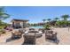 Outdoor firepit lounge area with comfortable seating, lush landscaping, and community pool at 1272 W Camina Buena Vis, Queen Creek, AZ 85140
