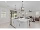 Open-concept kitchen with island seating and stainless steel appliances overlooking living area and backyard at 1272 W Camina Buena Vis, Queen Creek, AZ 85140
