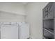 Functional laundry room with shelving and a modern storage cabinet at 1272 W Camina Buena Vis, Queen Creek, AZ 85140